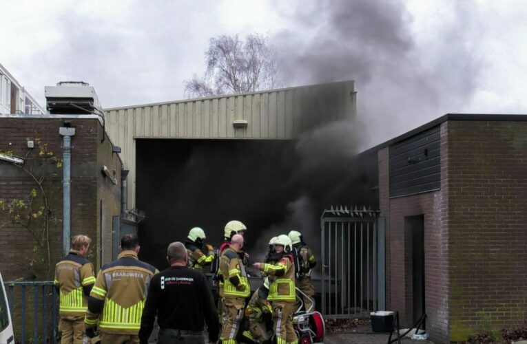 Brandweer blust brand bij garageboxen in Enschede